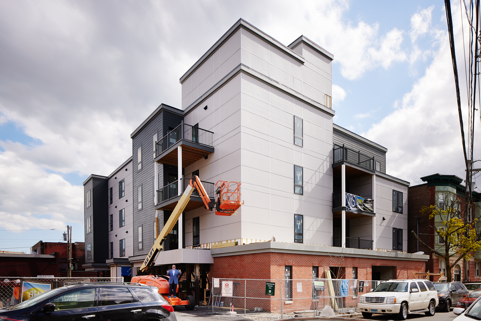 New apartment building under construction with a boom lift at 163 Chestnut Street in Chelsea, Massachusetts