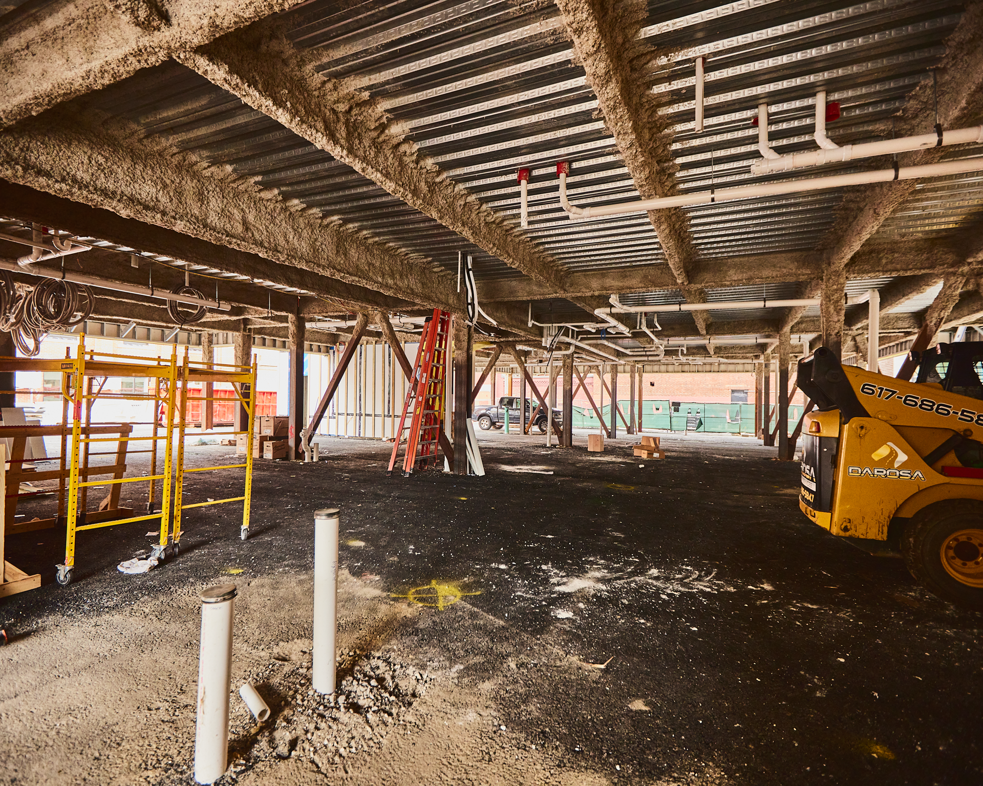 Parking-level construction interior with exposed steel and scaffolding at 163 Chestnut Street in Chelsea, Massachusetts