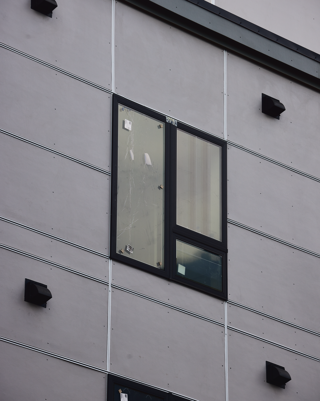 New apartment building facade with black-framed windows under construction at 163 Chestnut Street in Chelsea, Massachusetts